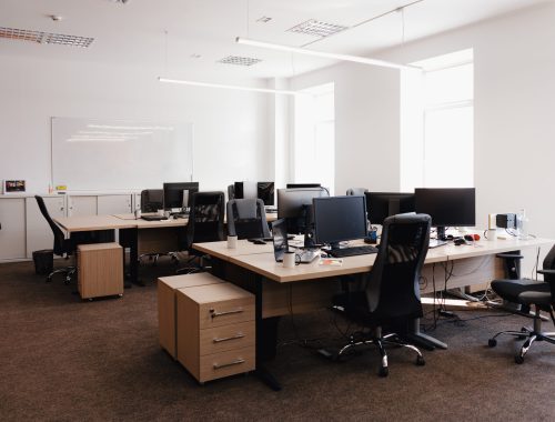 IT open space office. Computer Work Stations. Office Workplace with windows.